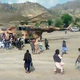 A number of people crowd around military helicopters transporting injured away from quake-affected areas in Afghanistan.